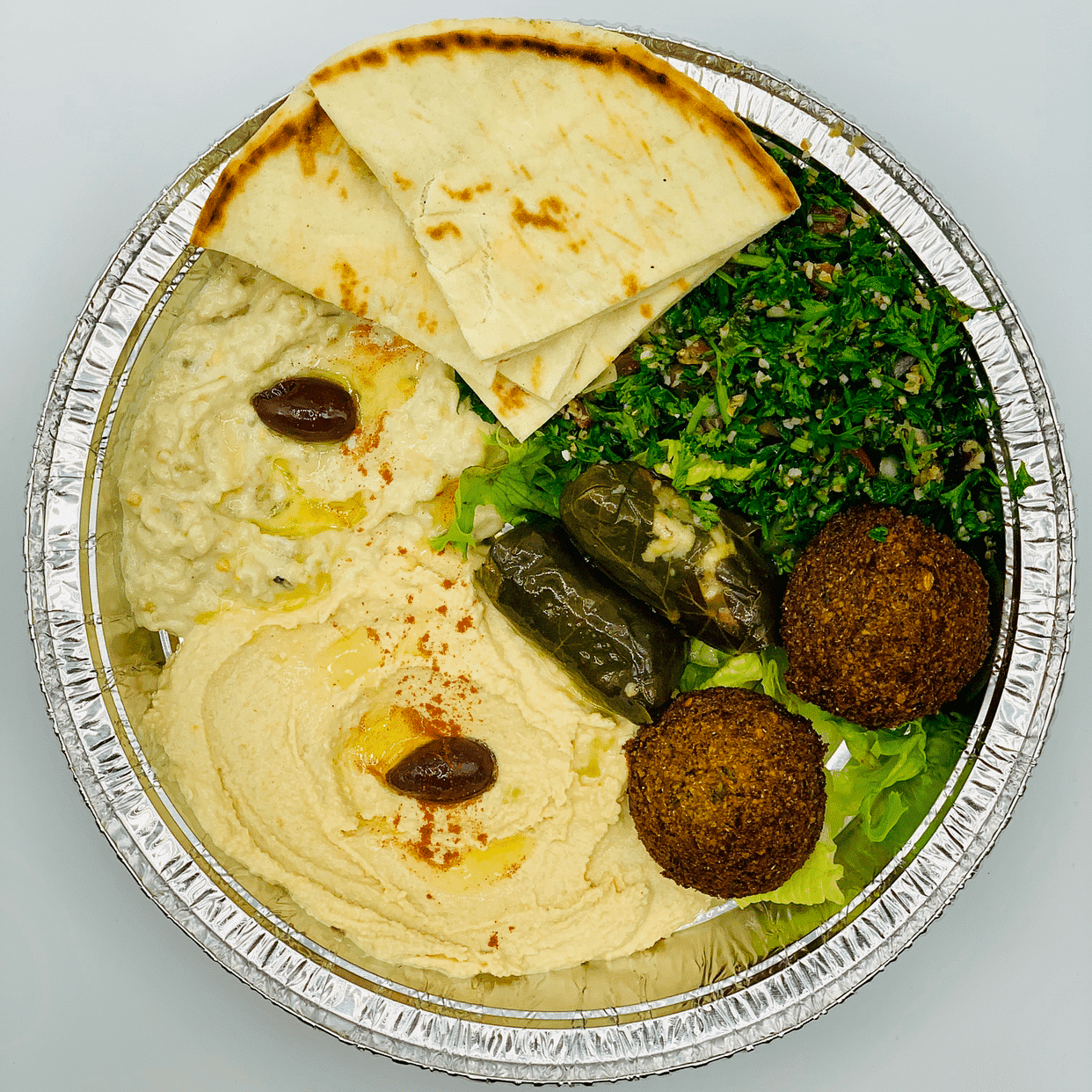 Hummus platter with pita bread, falafel, dolma, and olives